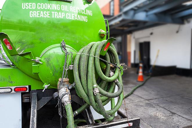 a grease trap being pumped by a sanitation technician in Pennellville NY